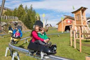 a woman and child riding on a roller coaster at Apartments by GMS in Katschberghöhe