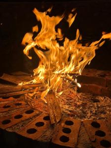 a fire is burning in a brick oven at Highfield Villa in Kanatal +33 photos