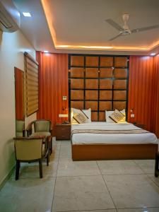 a bedroom with a large bed and a chair at Hotel Roselle inn in Jāmb