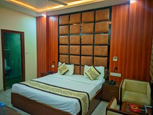 a bedroom with a large bed with a wooden headboard at Hotel Roselle inn in Jāmb