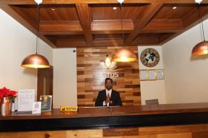 a man in a suit and tie sitting at a bar at Lotus Shines & Amenities in Manamaiju +30 photos