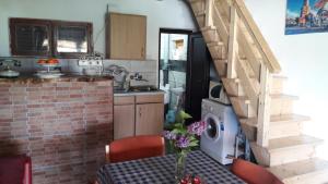 a kitchen with a table and a staircase in a kitchen at Vikendica Dunav i SAVA in Donji Milanovac