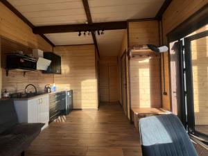 a kitchen with wooden walls and wooden flooring in a house at Nagoru house in Tukhlya