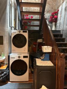 a washing machine in a room with a staircase at Dé Cafe & Rest House in Ipoh