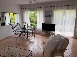 a living room with a table and chairs and a television at Chez Christine in Callian