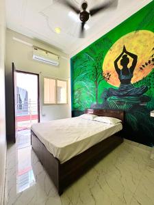 a bedroom with a bed with a painting on the wall at Mountain View Terrace Room Upper Tapovan in Rishīkesh +3 photos