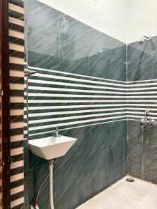 a bathroom with a sink and black and white tiles at Mountain View Terrace Room Upper Tapovan in Rishīkesh