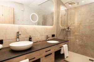 a bathroom with a sink and a large mirror at Hotel Kristall in Grossarl +69 photos