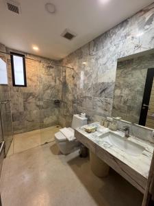 a bathroom with a toilet and a sink and a shower at Mango Tree Resort in Chiang Mai