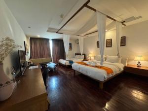 a bedroom with two beds and a canopy bed at Mango Tree Resort in Chiang Mai