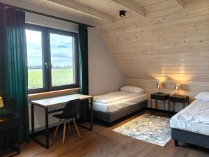 a room with two beds and a desk and a window at Dolina Biebrzy - Siedlisko Wroceń 57 in Wroceń