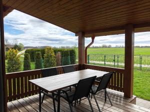 a wooden deck with a table and chairs on it at Dolina Biebrzy - Siedlisko Wroceń 57 in Wroceń