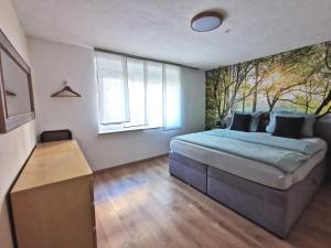 a bedroom with a bed and a large window at Ferienwohnung im Erdgeschoss direkt am Rad- und Spazierweg in Silz