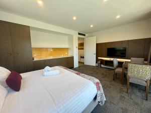 a hotel room with a bed and a desk and a television at Young Federation Motor Inn and Services Club in Young