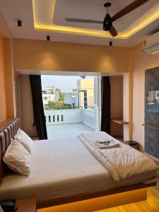 a large bed in a bedroom with a balcony at Hotel Vyankatesh Inn in Nashik