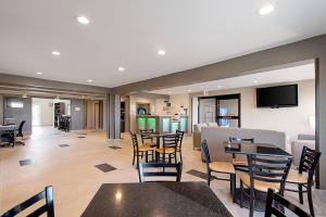 a restaurant with tables and chairs and a flat screen tv at Quality Inn Mishawaka - South Bend in Mishawaka