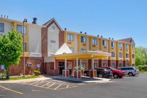 a large yellow building with cars parked in a parking lot at Quality Inn Overland Park Kansas City in Overland Park