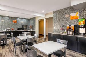 a restaurant with tables and chairs and a bar at Quality Inn Overland Park Kansas City in Overland Park