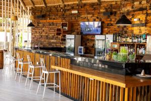 a bar in a restaurant with bar stools at Giraffe Beach Hotel in Dar es Salaam