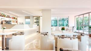 a restaurant with white tables and chairs at Hotel Naica in Rimini