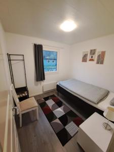 ein kleines Schlafzimmer mit einem Bett und einem Stuhl in der Unterkunft Öjavad in Svängsta