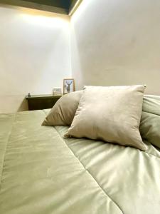a large white bed with two pillows on it at Pescasseroli Home in Pescasseroli