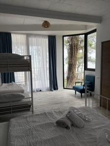 ein Schlafzimmer mit Bett, Stuhl und Fenstern in der Unterkunft Mana-Mana in Grigoleti + 84 Fotos