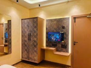 a room with a wall with a tv and a door at Hotel Vyankatesh Inn in Nashik +53 photos