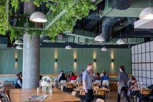 un restaurant avec des tables en bois et des personnes assises à table dans l'établissement Quest Dandenong Central, à Dandenong