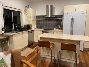 a kitchen with white cabinets and a white refrigerator at Bexhill Grace in Lismore