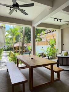 a living room with a wooden table and benches at Nira Hostel Kuta Lombok in Kuta Lombok