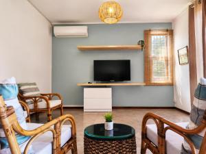 a living room with a tv and a couch and chairs at La Maison d'Isa in Albion