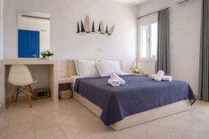 a bedroom with a bed with two towels on it at Studio in a family hotel in Perivolos +36 photos