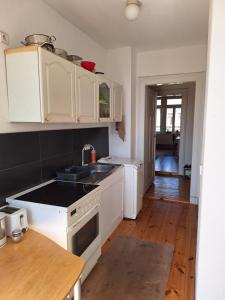 a kitchen with white appliances and a wooden floor at Helles geteiltes Mehrbettzimmer in Leipzig
