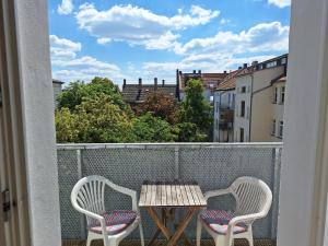 two chairs and a table on a balcony with a view at Helles geteiltes Mehrbettzimmer in Leipzig +3 photos
