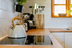 a white tea kettle sitting on top of a kitchen sink at Romantic Nights Under The Thatched Roof in Scharnebeck