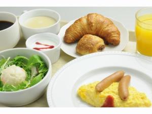 una tavola con un piatto di cibo e un piatto di cibo di Hotel Sunroute Kumagaya Station a Kumagaya