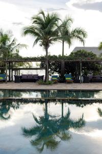 a pool of water with palm trees and chairs at Giraffe Beach Hotel in Dar es Salaam