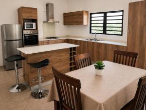 a kitchen with two tables with chairs and a counter at La Maison d'Isa in Albion