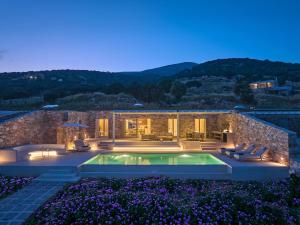 a villa with a swimming pool at night at Eos Villa in Drios