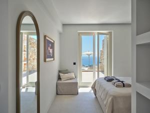a bedroom with a bed and a mirror and a chair at Eos Villa in Drios +46 photos