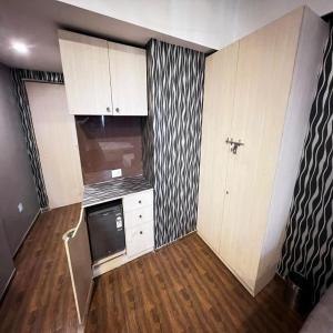 a kitchen with white cabinets and a black and white wallpaper at Weekend address in Surat