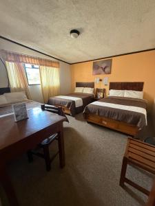 a hotel room with two beds and a table at Hotel Santa Fe in Chignahuapan