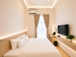 a hotel room with a bed and a flat screen tv at Amory Airport Hotel in Ho Chi Minh City