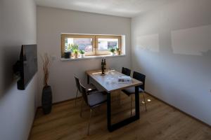 a dining room with a table with chairs and a window at Apartmány LISON in Valtice