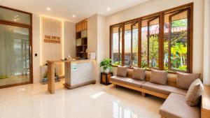 a living room with a couch in a building at The Fifth Residence in Bangkok