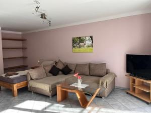 a living room with a couch and a tv at Gästehof Huber in Forstern