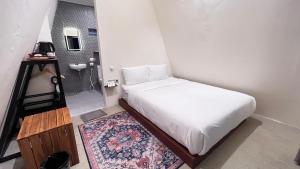 a small bedroom with a bed and a bathroom at Arjuna Hill in Sumberbrantas