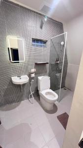 a bathroom with a toilet and a sink at Arjuna Hill in Sumberbrantas