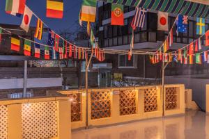 a bunch of flags hanging from a building with a lot of floors at 행궁주택 in Samgong